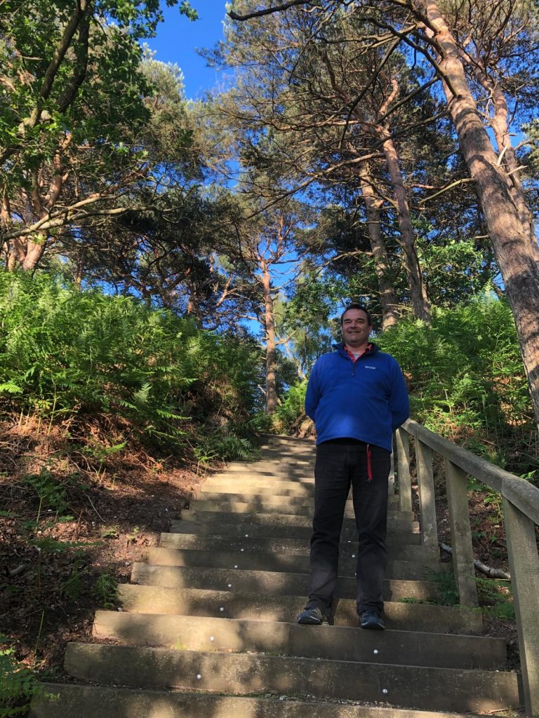 Walking up the steps from Pottery Pier, under pine trees with lapis blue sky.