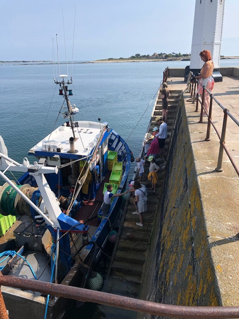 Fisherman showing children the catch